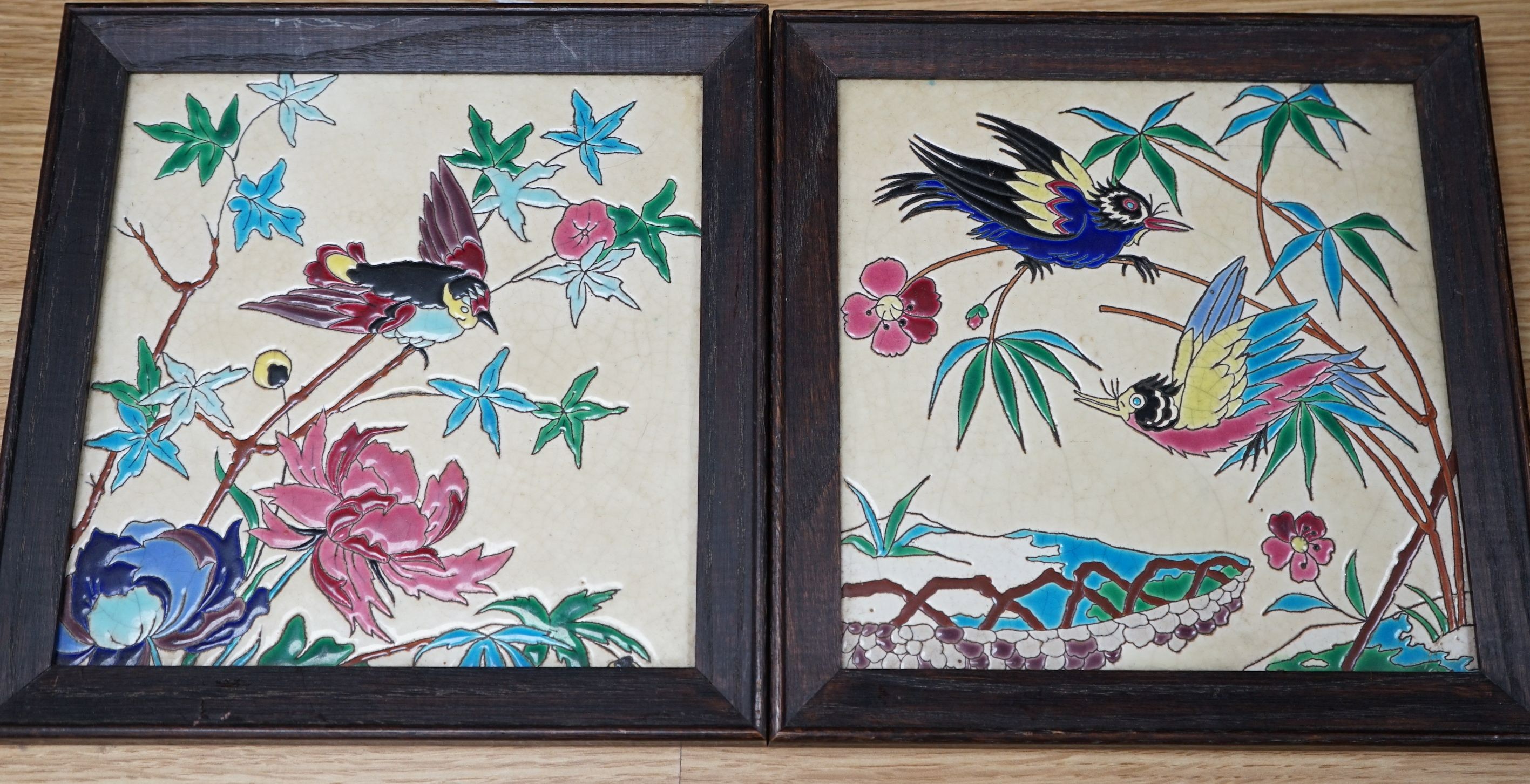 A pair of Longwy framed tiles, 19cms square